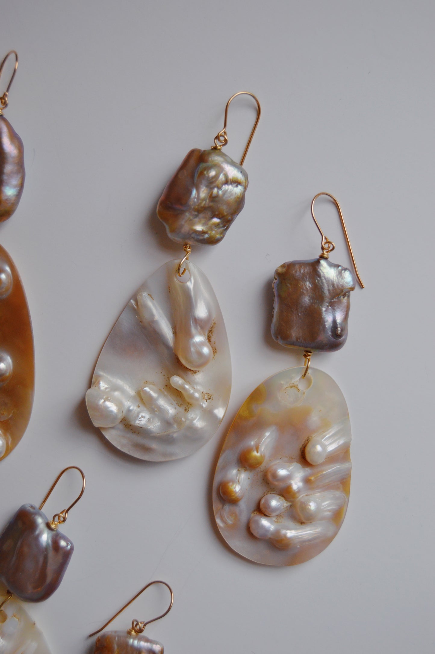 Angel Shell Drops: Dangle earrings with irregular, shiny square and teardrop-shaped cultured freshwater pearls on 14k gold-filled hooks, shown against a white background.