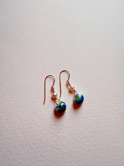 Bubble Minis are dangle earrings with gold-filled hooks, small white beads, and round blue and green glass beads, shown on a light textured surface.