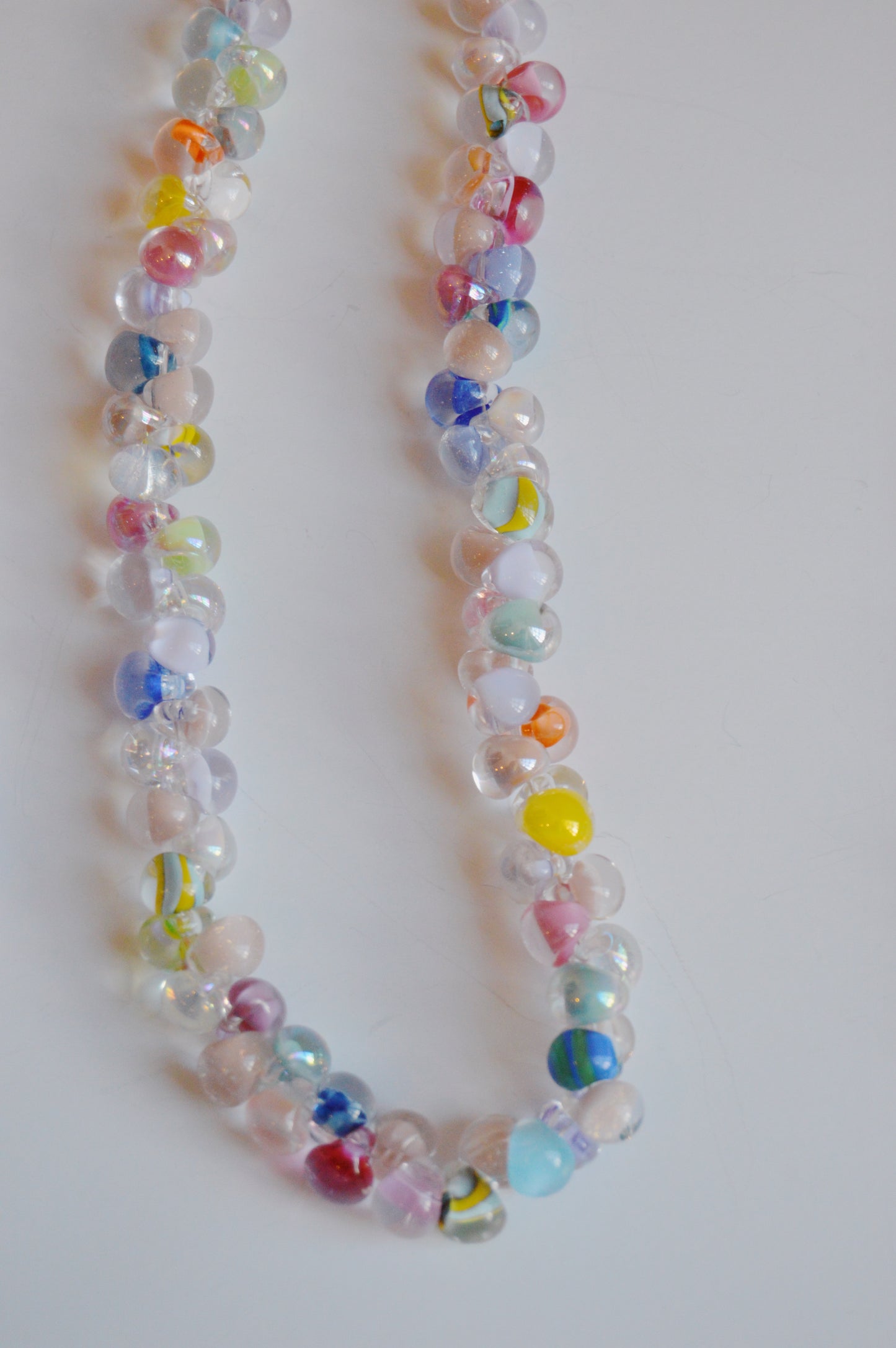 A close-up of the Rainbow Bubble Glass Necklace, featuring handmade round lampwork beads with colorful swirls and spots, displayed on a white background.