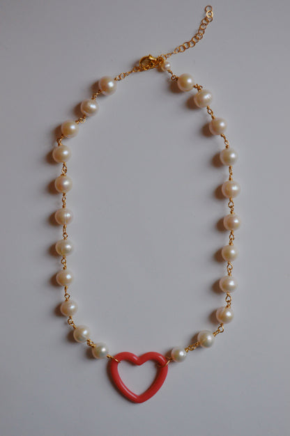 The Open Heart on Pearl Chain features large white freshwater pearls linked with gold-filled findings and clasp, accented by an acrylic heart charm pendant at the center.