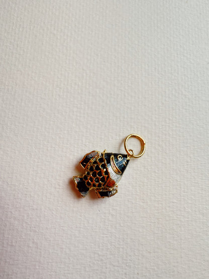 The Fish Anklet features a small gold and black cloisonné fish charm with a loop for attaching to the gold plated chain, beautifully displayed on a textured white background.