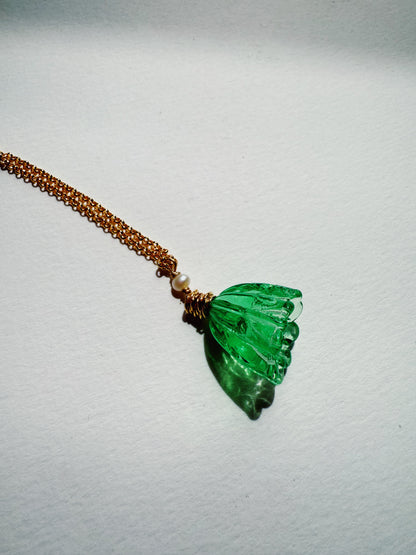 The Tulip Necklace features a 14k gold filled chain with a green handblown glass tulip pendant and a cultured freshwater pearl, displayed on a plain white surface.