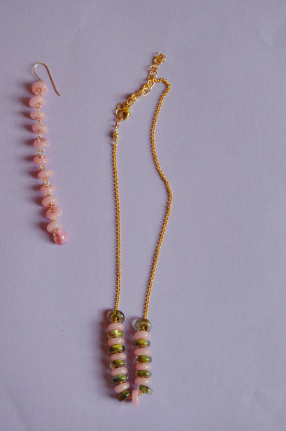 The Fall Lots of Donuts Layer features a gold chain necklace and matching earring with handblown pink and green glass beads, set on a light purple background with elegant 14k gold filled findings.