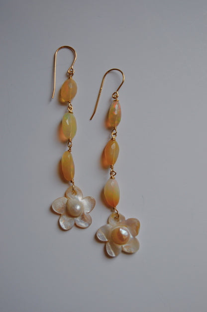 Opal & Pearl Flower Drops feature 14k gold-filled hooks, three oval yellow beads, and a Mother of Pearl flower charm, displayed on a plain light background.