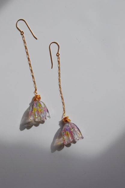The Glass Tulips Earrings- Bloom are artisan-made gold chain drop earrings with translucent, flower-shaped pendants in pink, yellow, and green hues, beautifully displayed on a white surface with soft shadows.
