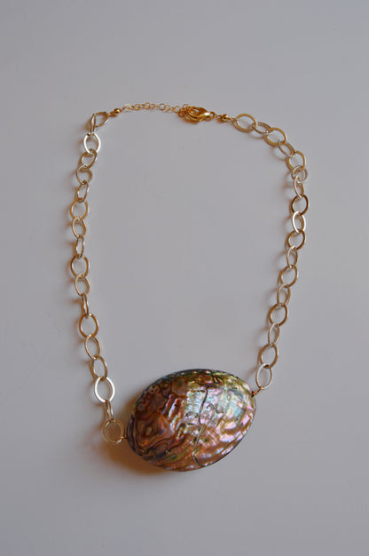 The Sterling Silver Abalone Layer is a necklace featuring a large, oval iridescent abalone shell pendant, made from genuine abalone and displayed against a plain white background.