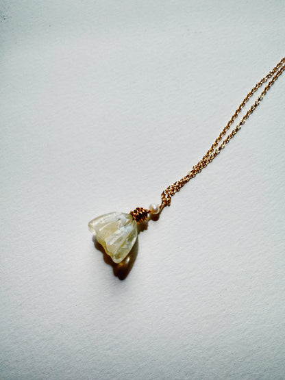 The Tulip Necklace features a gold-filled chain and a handblown glass tulip pendant, carved to resemble a flower and accented with a cultured freshwater pearl, shown against a light background.