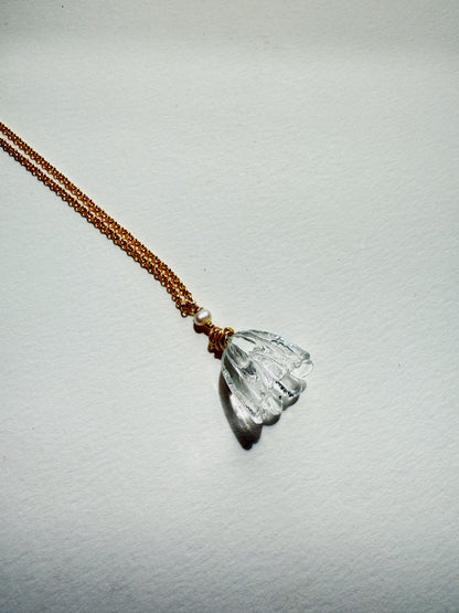 The Tulip Necklace features a 14k gold filled chain with a carved clear crystal flower pendant and a small cultured freshwater pearl, shown on a plain white background.
