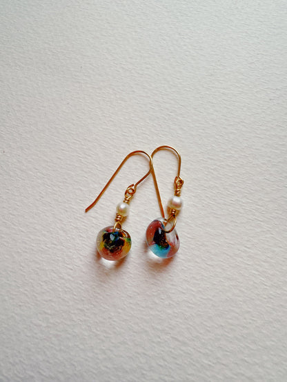 Bubble Minis: Gold hook earrings with gold filled findings, small white freshwater pearls, and round multicolored glass beads. Displayed on a textured white surface.