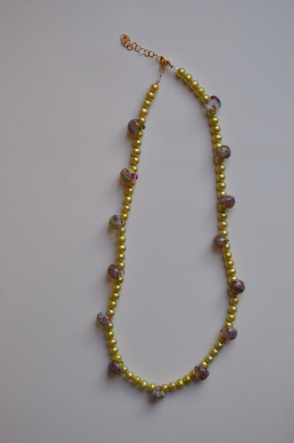 The Bubble and Pearl Layer necklace features small yellow beads, handmade floral lampwork glass beads, and larger round beads, all displayed on a plain white background.