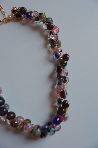 A close-up of the Bubble Glass Necklace - Fall Mix, featuring round, handblown glass beads in pink, purple, blue, and brown with gold-filled accents, set against a plain white background.