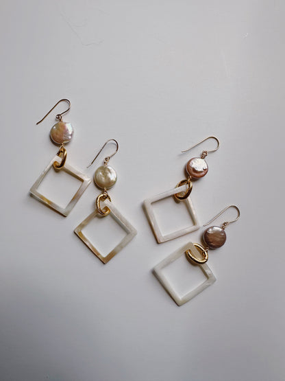 The Diamond Shell and Pearl Drops are dangling earrings with irregular cultured freshwater pearls, a gold ring, and a geometric square charm on gold-filled hooks, all shown on a plain white background.
