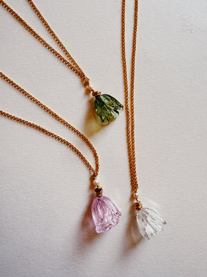 Three Tulip Necklaces featuring 14k gold filled chains and handblown glass pendants in green, pink, and clear are arranged on a white surface.