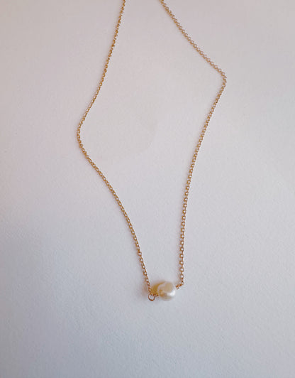 The Dainty Single Pearl Layer features a delicate 14k gold filled chain with a single round cultured freshwater pearl pendant, shown on a plain white background.