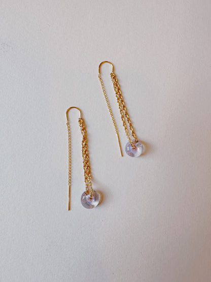 Glass Donut Threaders: 14k gold filled earrings with delicate chains, each adorned with a small translucent lavender bead at the end, displayed on a light neutral background.