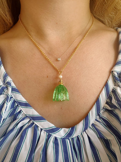 A person wears a blue and white striped blouse with two necklaces: the Tulip Necklace, a 14k gold filled chain with a handblown glass tulip pendant, and a shorter chain adorned with cultured freshwater pearls.