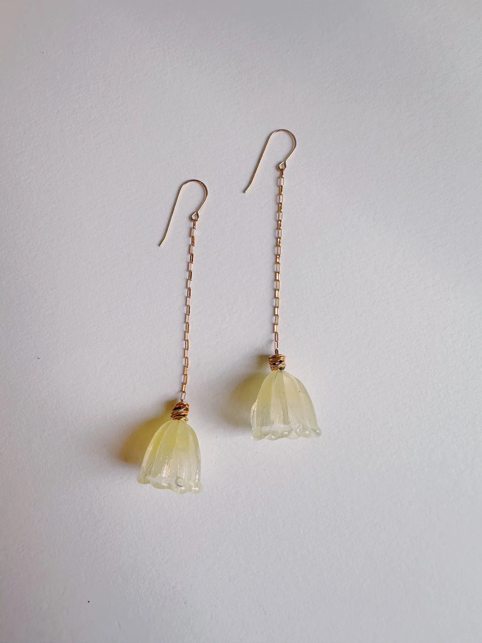 Glass Tulip Earrings in hazy lemon feature long, 14k gold-filled chains with handmade translucent lampwork tulip pendants, showcased on a white background—a beautiful example of glass artist jewelry.