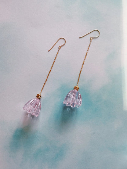 Glass Tulip Earrings feature long, thin 14k gold-filled chains and hooks, each ending in a clear light pink handmade lampwork tulip charm, shown on a soft blue and white background.
