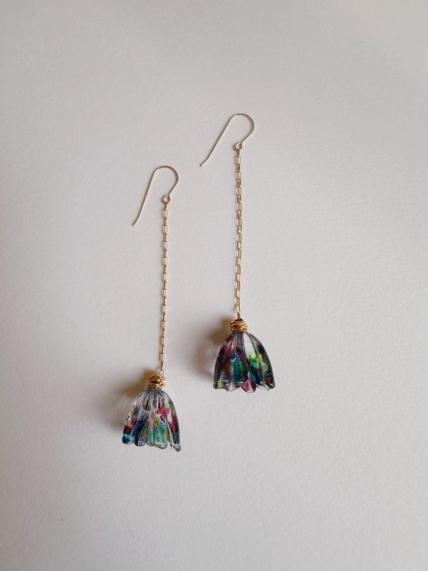 Glass Tulip Earrings in Tie Dye feature long 14k gold-filled chains and delicate handmade multicolored glass lampwork tulip pendants, shown on a plain white background.